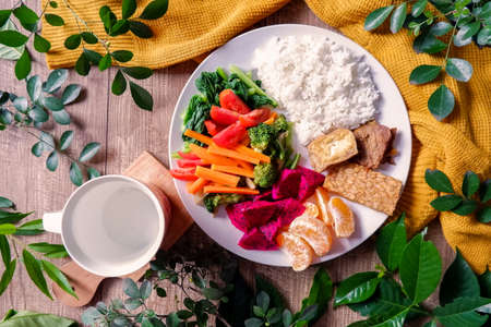 simple healthy foods diet menu with rice, tempeh, tofu, veggies and fruits on flat lay - top viewの写真素材