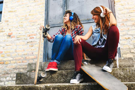 Skate girls sitting in the street hanging outの写真素材