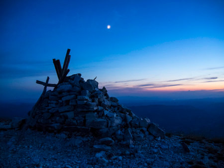 Summit cross and moon at sunset, mount Acuto, Apennines, Italyの写真素材