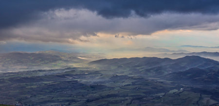 View of valleys just before a storm with clouds and fog, winter, Monte Cucco NP, Umbria, Italyの写真素材