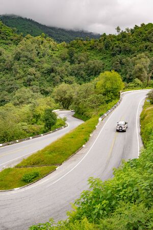 A car traveling along a  winding road in a lush rainforest scenery, next to Monumento al Indio, on the route to Tafi del Valle, Tucuman. Argentina. High angle shot.のeditorial素材
