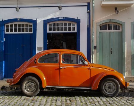 OURO PRETO, MINAS GERAIS, BRAZIL - DECEMBER 24, 2019: Orange retro car Volkswagen Beetle parked  on the street in the ancient city of Ouro Preto, Brazil. Volkswagen Type 1, best known as "Beetle car" is an economy car produced by Volkswagen from 1938 untiのeditorial素材