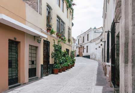 Picturesque urban landscape with colonial style buildings, flower pots and cobbled street in Arequipa, Peruの写真素材