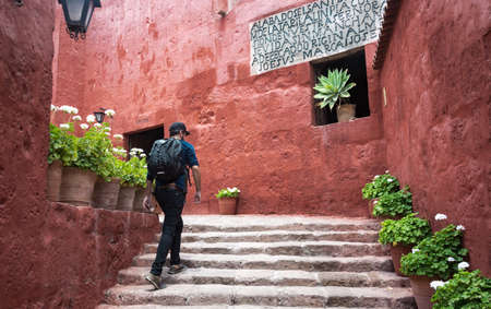 AREQUIPA, PERU - JANUARY 17, 2018: A tourist walks up the steps in beautiful urban scenery. Monastery of Santa Catalina in Arequipa, PerÃºのeditorial素材