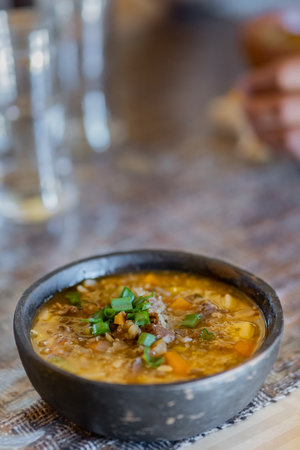 Quinoa stew with vegetables and beef in a rustic black stoneware pot. Traditional Andrean food. Salta, Argentina. The northern regions of Argentina have a notable indigenous influence and therefore, are excellent destinations to savor the most typical and ancient foodsの写真素材