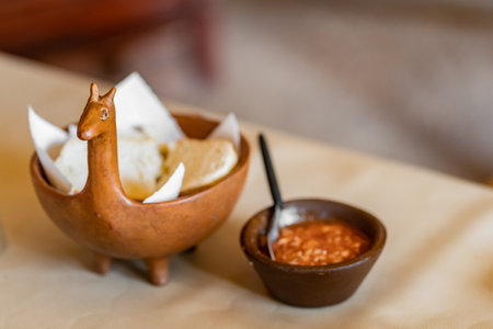 Traditional earthenware pottery from North of Argentina with bread a spicy tomatoe sauce. Cute llama shape pot. The northern regions of Argentina have a notable indigenous influence and therefore, are excellent destinations to savor the most typical and ancient foodsの写真素材