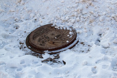 RUSSIA - FEBRUARY, 2018: Sewer manhole on the road in winterのeditorial素材