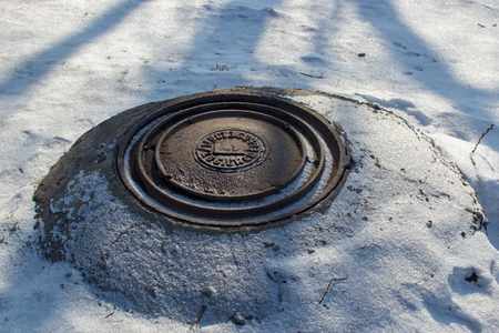 RUSSIA - FEBRUARY, 2018: Sewer manhole on the road in winterのeditorial素材