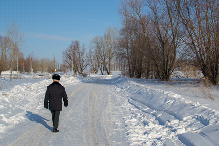 Man walks on a road in winterの写真素材