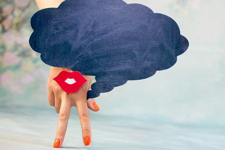 Female hand with two fingers down smile and red lips on a blue background and regional thoughtsの写真素材