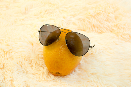grapefruit with sun protective glasses on light backgroundの写真素材