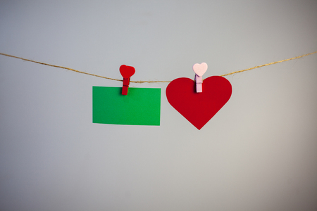 Sticker and little heart rests on the clothespin on the ropeの写真素材
