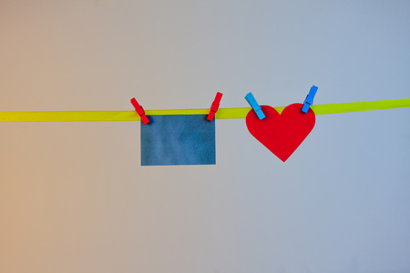 sticker and heart hanging on tape on wooden clothespinの写真素材