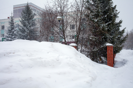 Snow storm in the city, big heaps of snow, cityscape in winterの写真素材