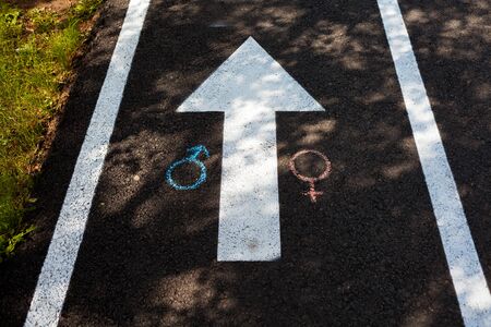 Chalk drawings on the asphalt. Gender symbols on the pavement. Man and Woman symbols