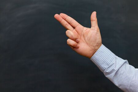 male hand making a gun gesture. chalkboard backgroundの写真素材