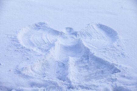 A snow angel made in the white snow.の写真素材