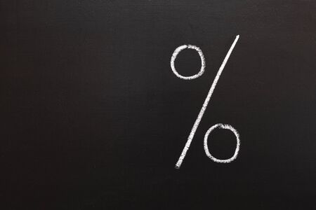 the percentage sign in red is on a chalkboard.の写真素材