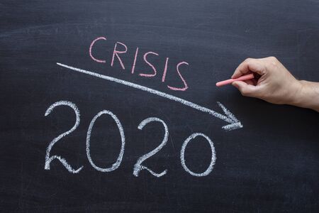 The concept of crisis, 2020 down arrow on the chalk Board