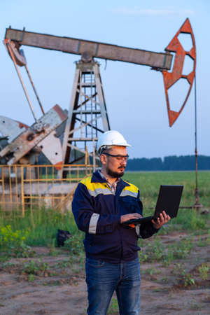 A engineer with a laptop of an oil pump