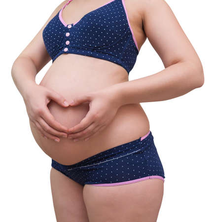 Pregnant Woman holding her hands in a heart shape on her stomach.