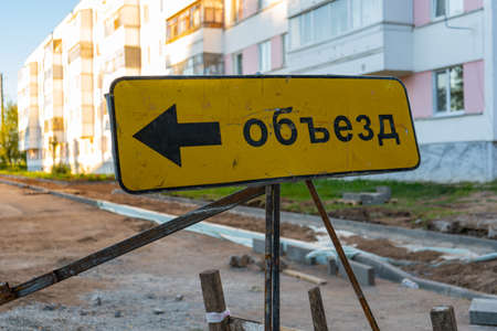 The inscription on the sign "Detour" in Russian. Road works in a residential areaの写真素材