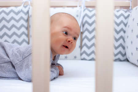 Newborn girl lifted her head for the first time while lying on her stomach. Selective focusの写真素材