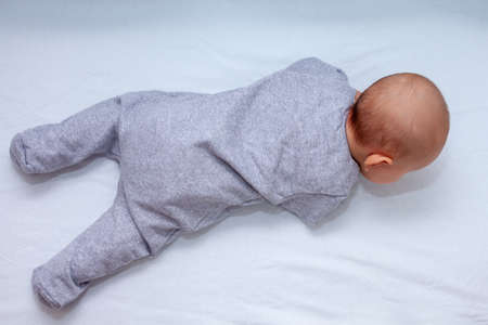 Top view, the newborn lies on its stomach in the cribの写真素材