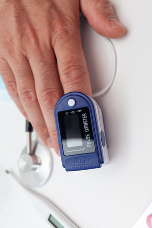 Male palm and oximeter. A man checks his blood oxygen level