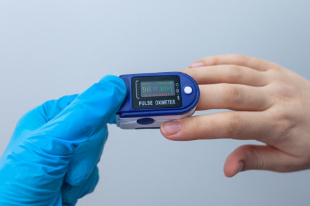 Doctor checks patient oxygen saturation using a portable oximeterの写真素材