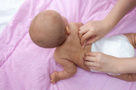 Mom gives back massage to newborn baby, top view