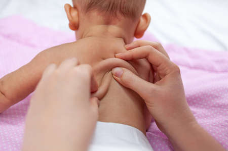 Mom gives back massage to newborn baby, top viewの写真素材