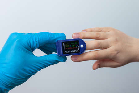 Doctor using pulse oximeter to check patient oxygen saturation