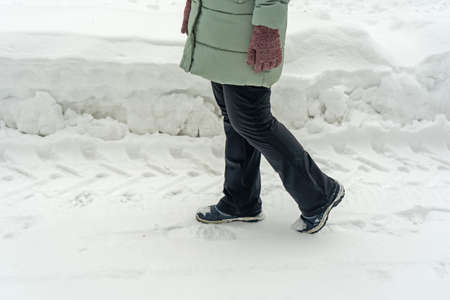 Female feet on a winter path in the parkの写真素材