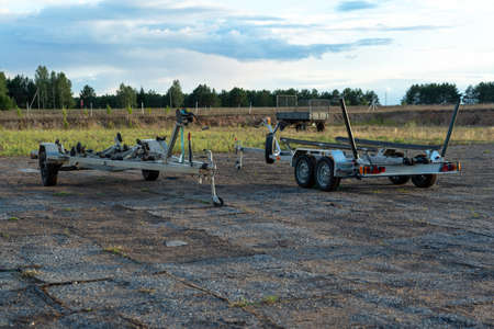 Two trailers for transporting motor boats are parked in the parking lot