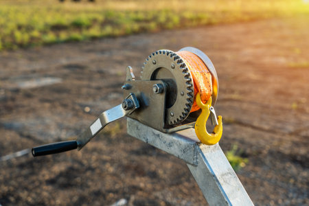 Boat trailer winch close-up, small metal mechanical wire yellow rope winch with a stainless steel hookの写真素材