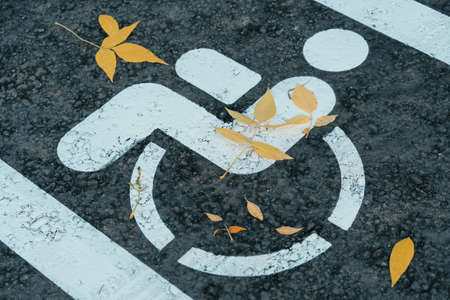 Drawing of a man in a wheelchair on the asphalt. Road sign parking for the disabledの写真素材