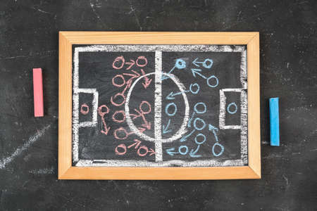 A diagram of a football game on a chalk board, top view. The teams are marked with red and blue chalkの写真素材