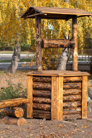 Old wooden well made of logs in the garden, garden plot designの写真素材
