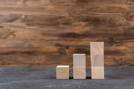 A stack of wooden blocks in the form of a ladder up, the concept of growth and development. Copyspace mockupの写真素材
