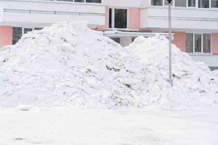 A huge pile of snow in the courtyard of an apartment building in Russiaの写真素材