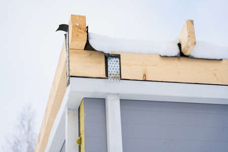 Rafter system on a building made of mineral wool insulated sandwich panels in winter