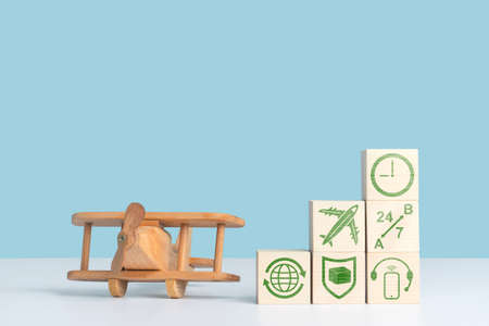 The concept of air transportation, delivery and logistics services. A wooden airplane toy stands at...