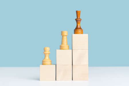 Chess pieces of white and black color stand on wooden cubes placed in the form of a ladder up. career development concept.の写真素材