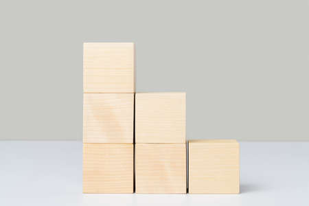 Wooden cubes arranged in the form of stairs and pyramids. Mockup for a business conceptの写真素材