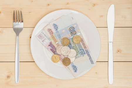 Inflation in Russia. Russian paper bills and coins lie on a white plate.の写真素材