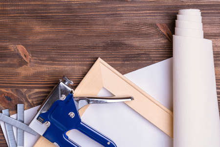 print photos on canvas. A tool for stretching canvas on a wooden stretcher. Pliers, stapler for staples and a roll of canvas.の写真素材