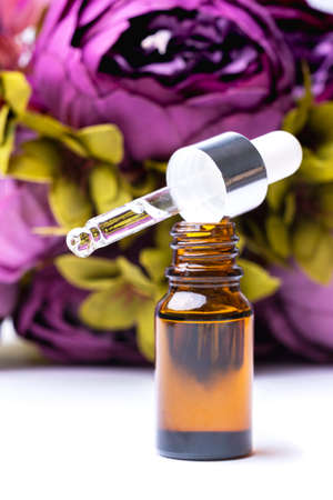 Essential oil and peony flowers in the backgroundの写真素材