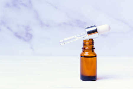 Essential oil in a bubble with a pipette on a white marble backgroundの写真素材