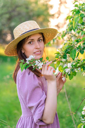 Portrait of a beautiful happy girl in a blooming apple orchardの写真素材